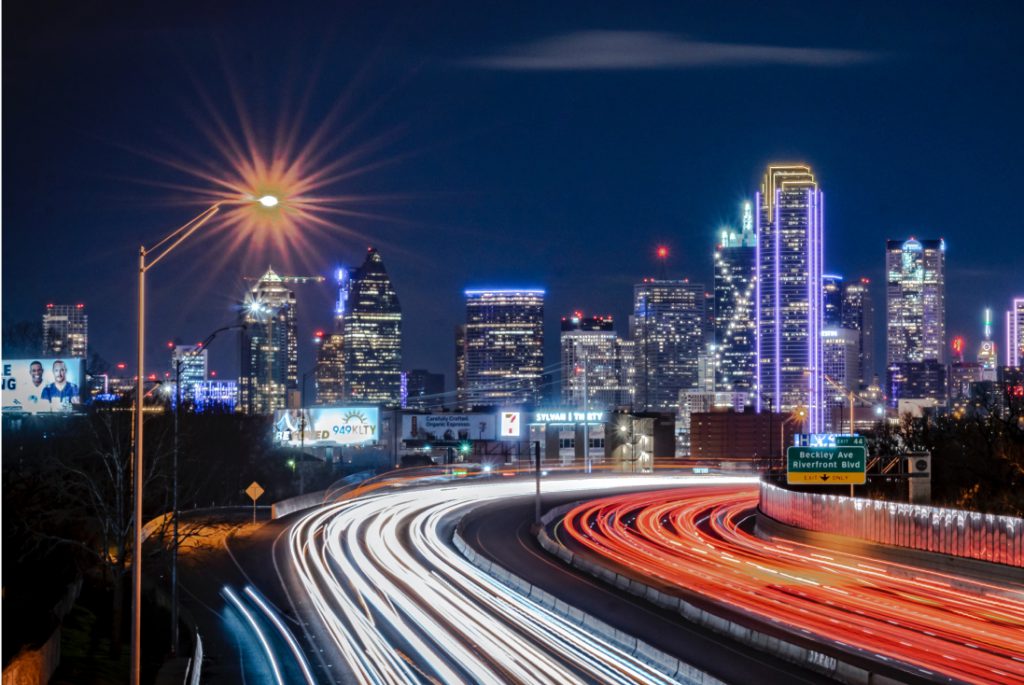 sentient-energy-Home Skyline at night with blurred headlights on the freeway.