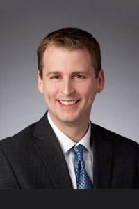sentient-energy-Jon Lund Headshot of Jon Lund wearing a suit and smiling.